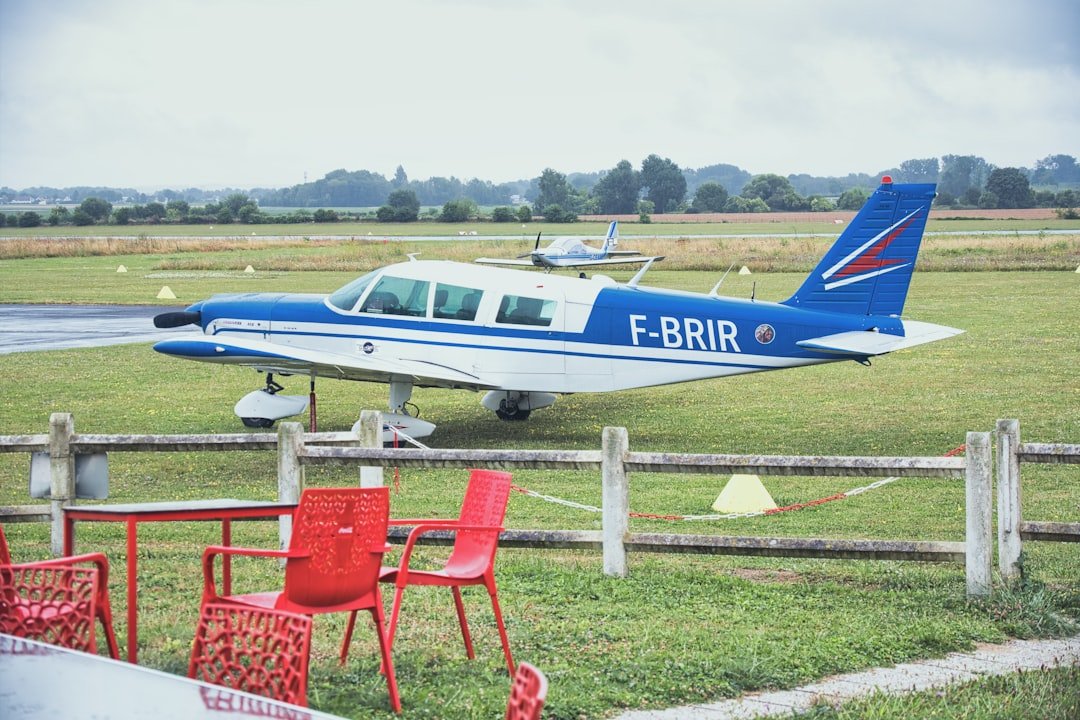 A small blue and white plane sitting on top of a field
