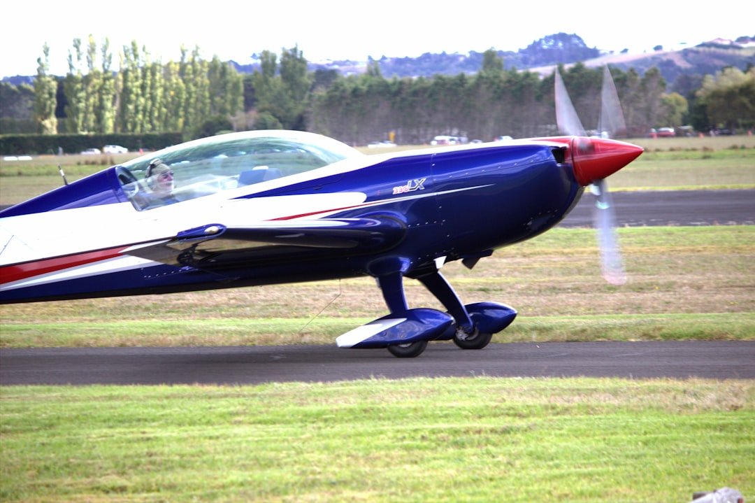 A blue airplane ready for takeoff on the tarmac.