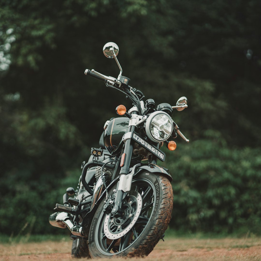 A motorcycle parked in a field with trees in the background