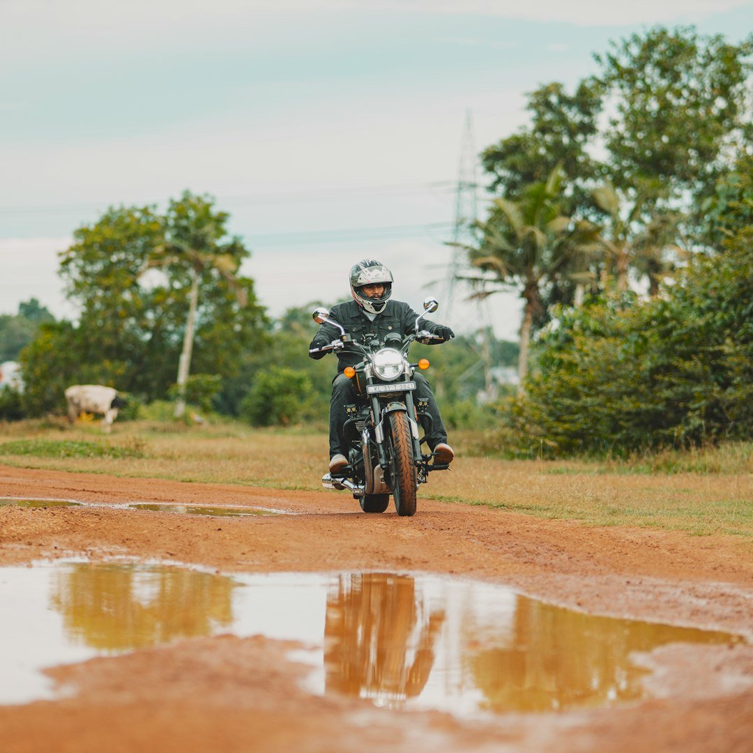 A man riding a motorcycle down a dirt road