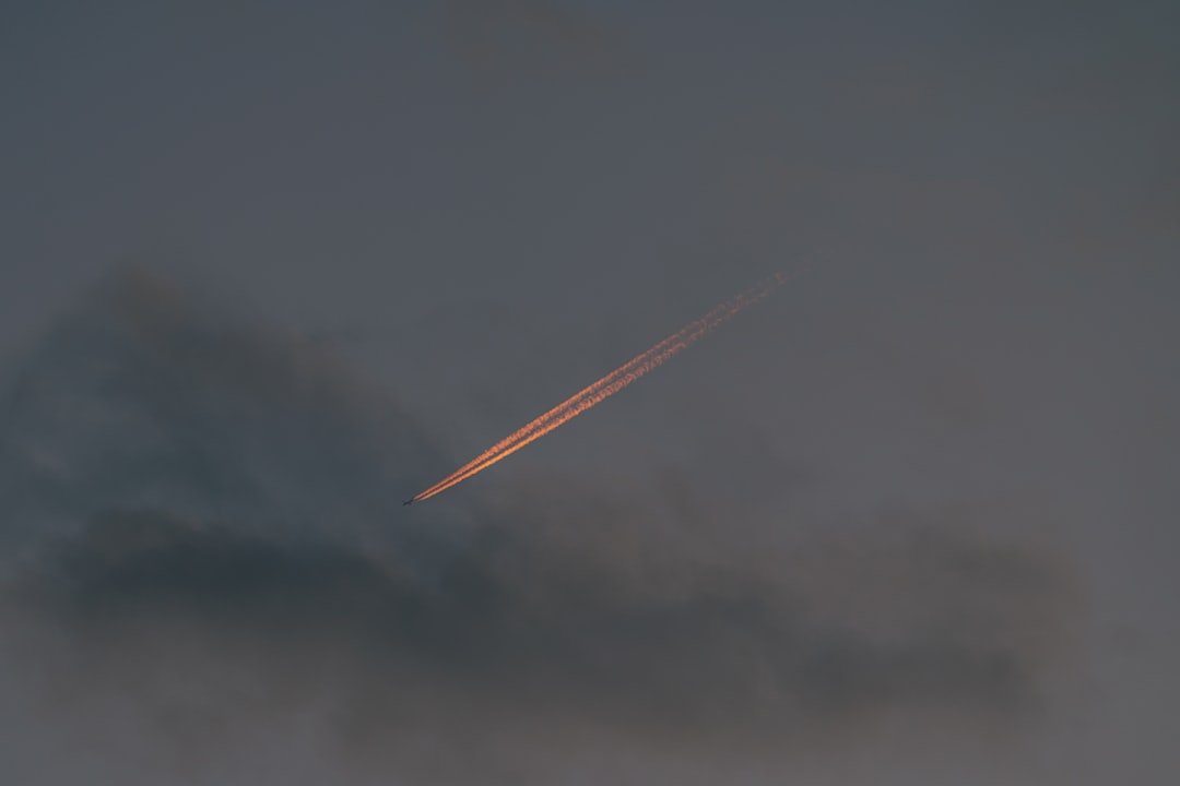 an airplane is flying in the cloudy sky