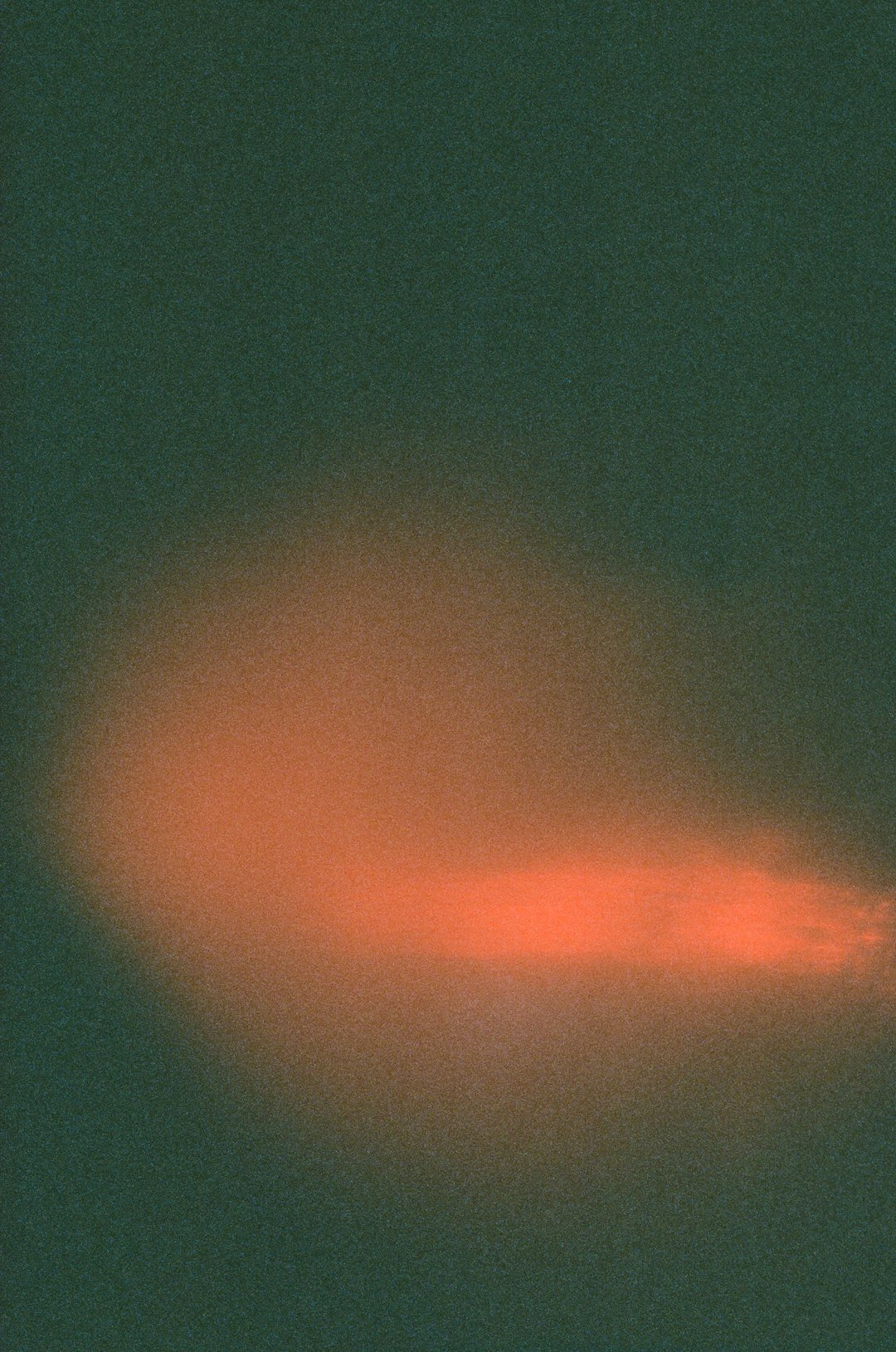 An orange glow against a dark, grainy backdrop.