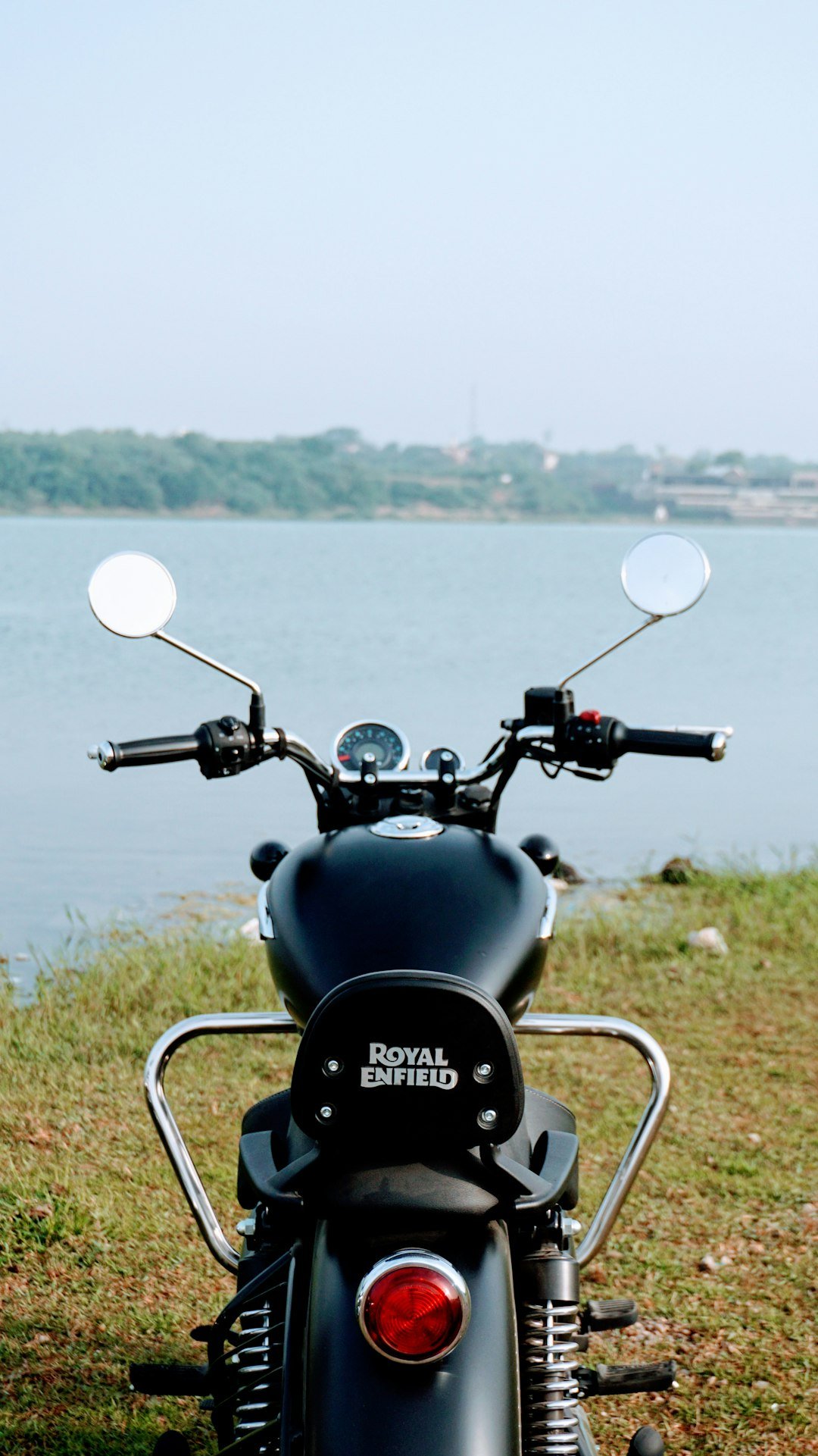 a black motorcycle parked on top of a grass covered field