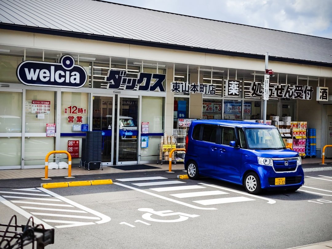 A blue van is parked in front of a store