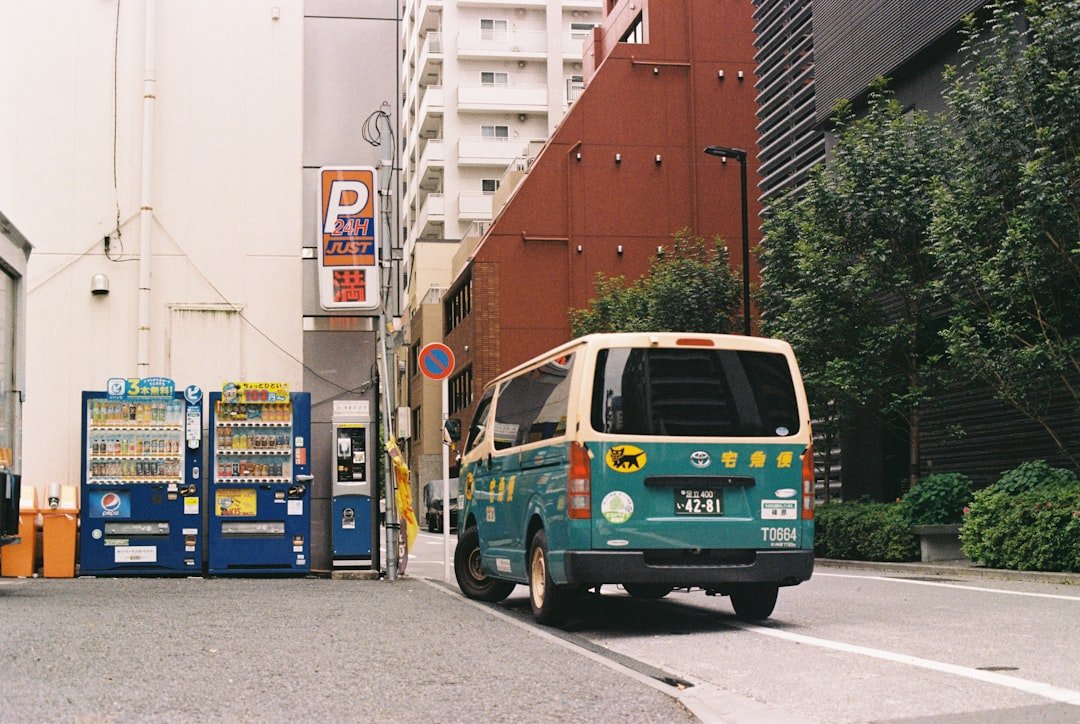 A van is parked on the street next to vending machines.