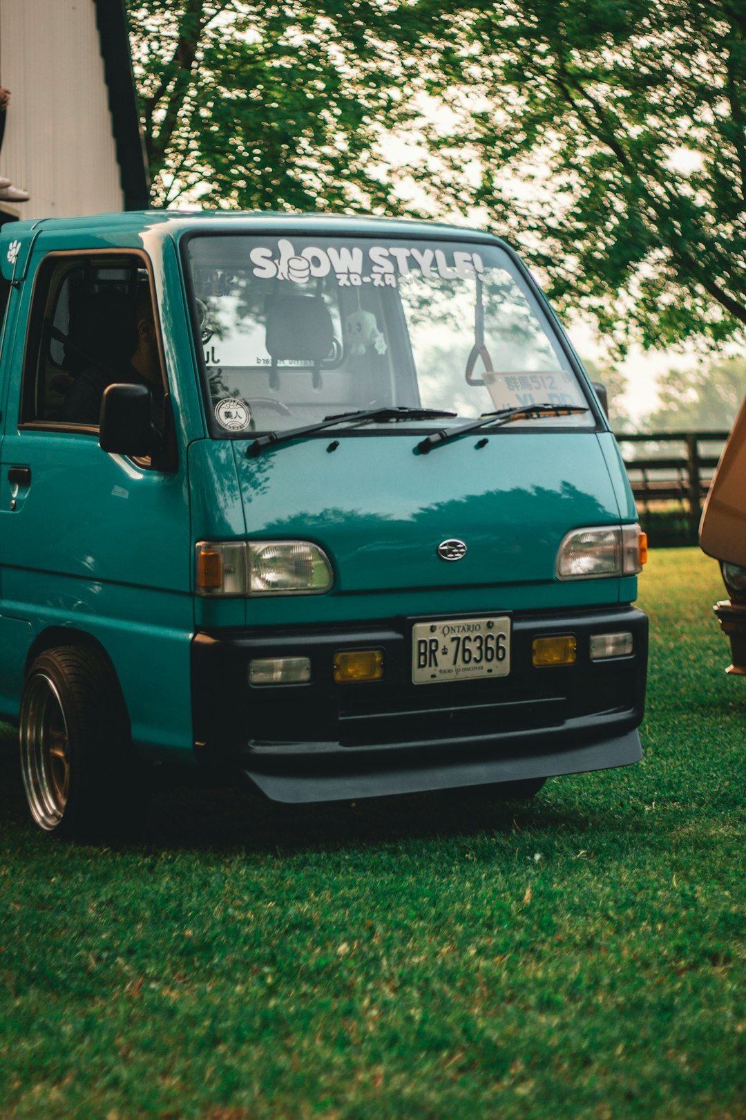 A small blue truck parked in the grass