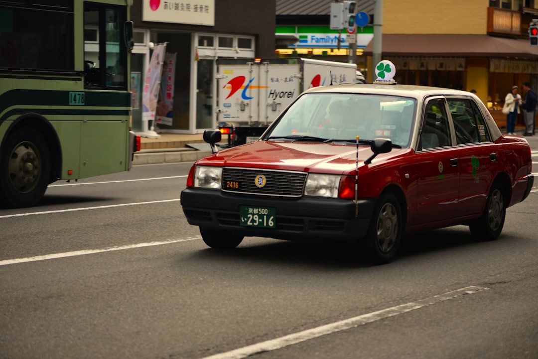 A red taxi drives down a street.