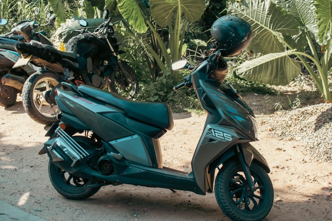 A scooter is parked near tropical greenery.
