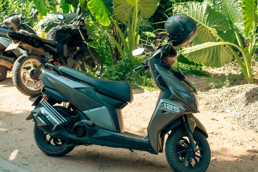 A scooter is parked near tropical greenery.