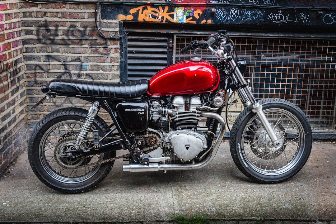 a red and black motorcycle parked in front of a building