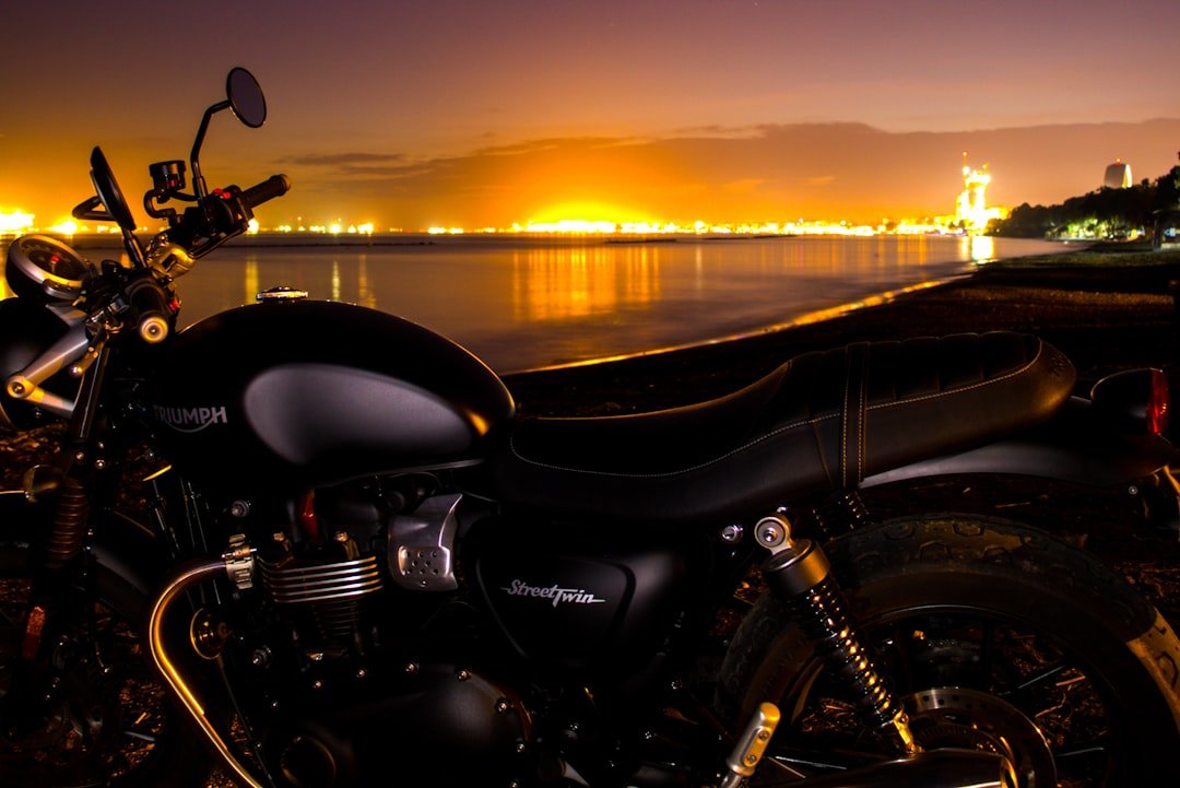 a motorcycle is parked near the water at night