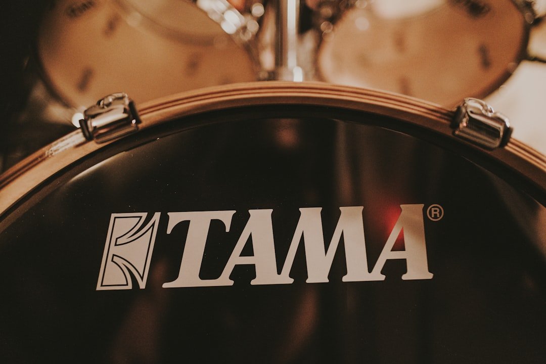 a close up of the tama logo on a drum set