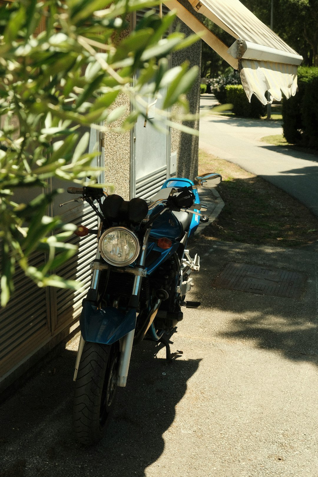 A blue motorcycle parked on the side of a road