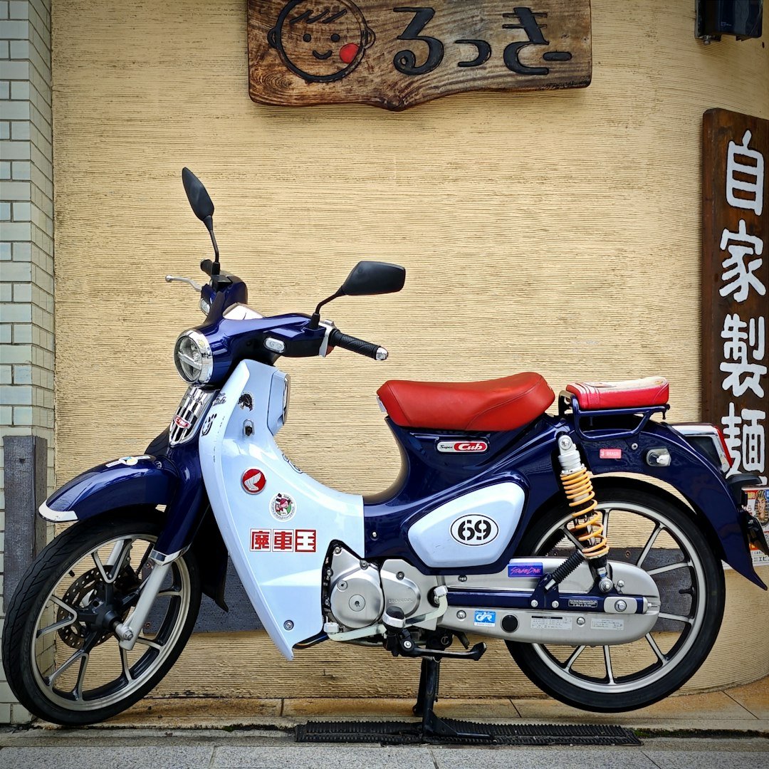 A blue and white motorcycle parked in front of a building