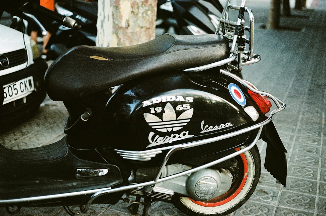 A motor scooter parked next to a tree