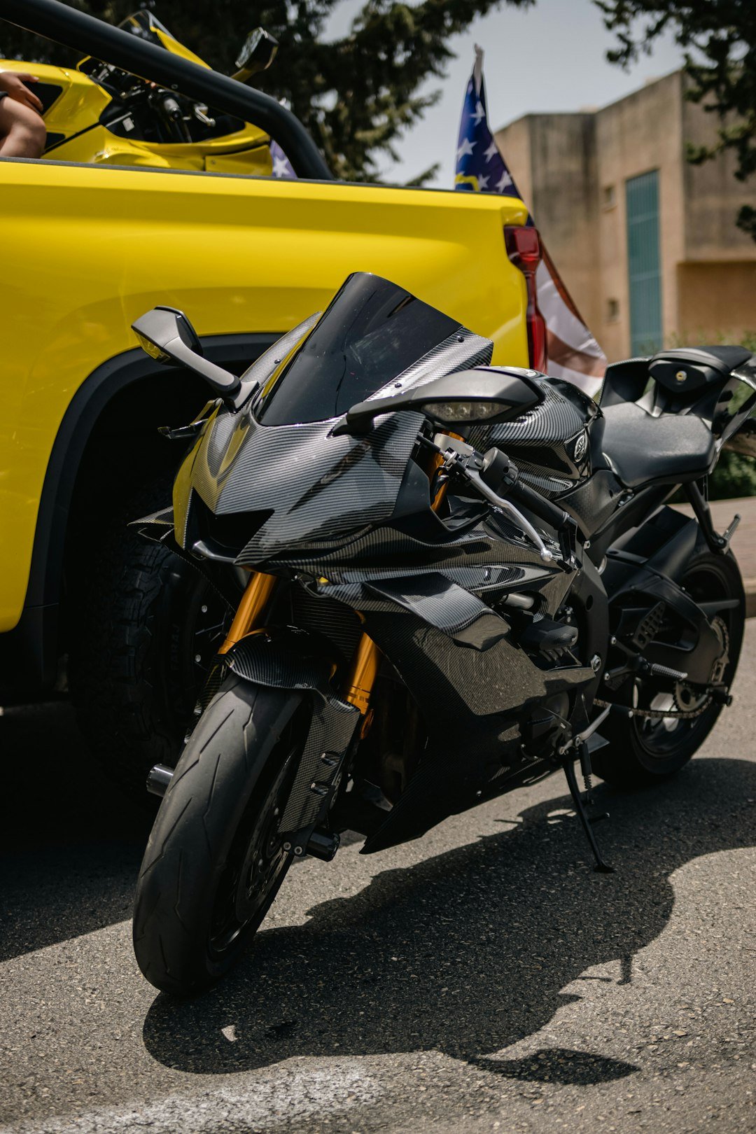 a black motorcycle parked next to a yellow car