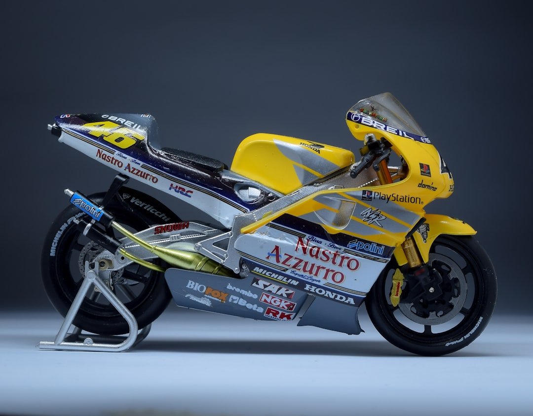 A yellow motorcycle parked on top of a white floor