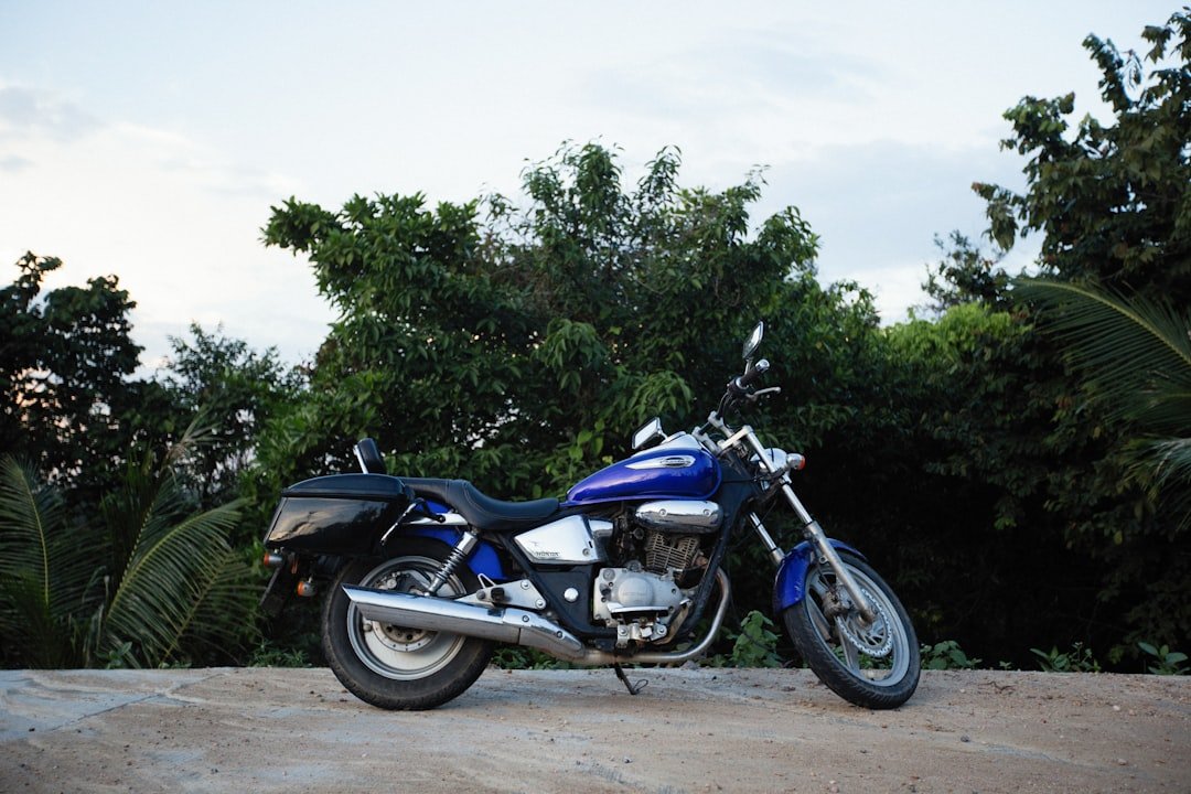 a blue motorcycle parked on top of a dirt road